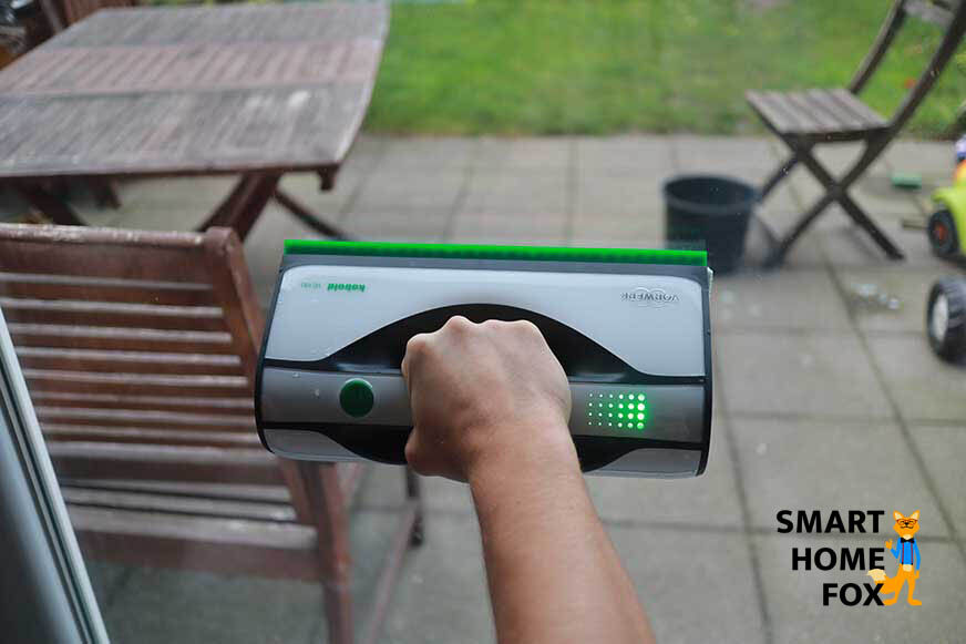 Man sieht, wie die Scheibe mit dem Vorwerk Kobold VG100 geputzt wird. 